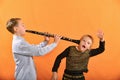 The boy plays the clarinet in the girlÃ¢â¬â¢s ear, the outraged girl waves her arms
